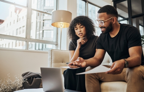 couple with laptop on sofa doing paperwork